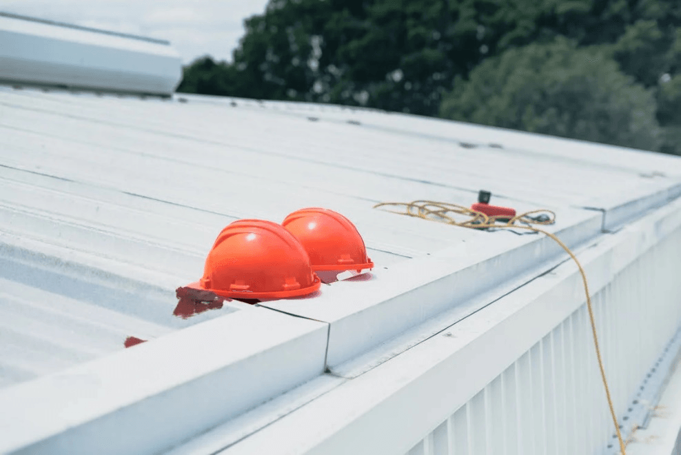 Two orange hard hats resting on a roof