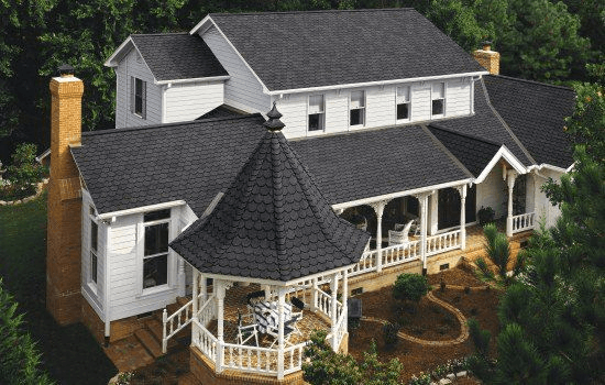 A stunning grey roof perched on top of a big house 
