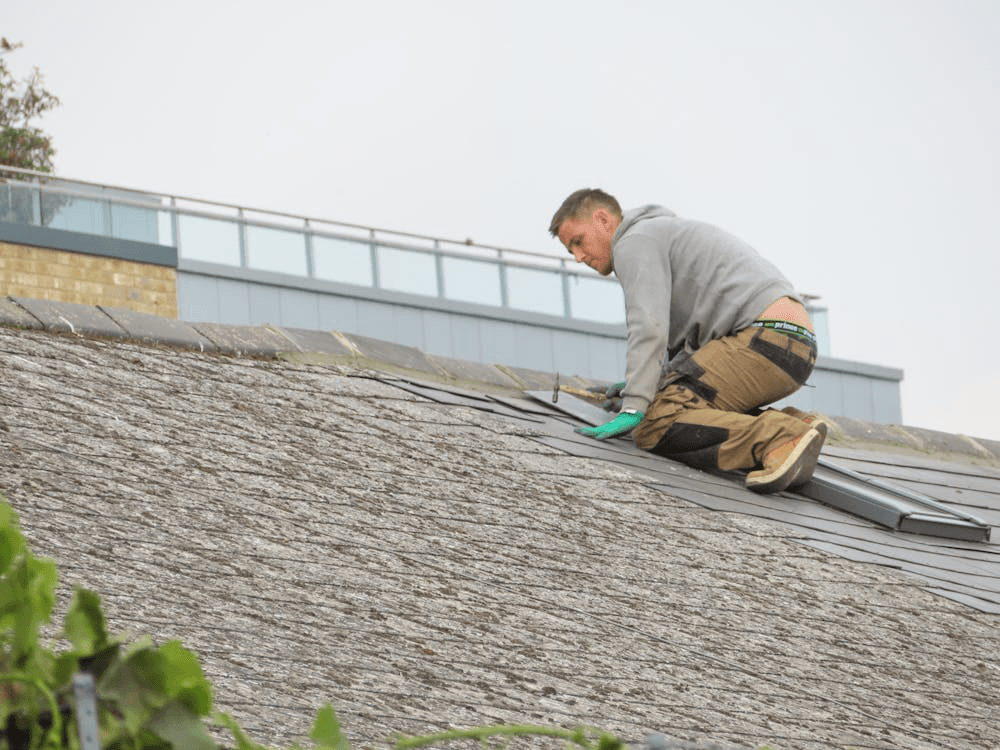 a distant view of a roofing contractor hard at work