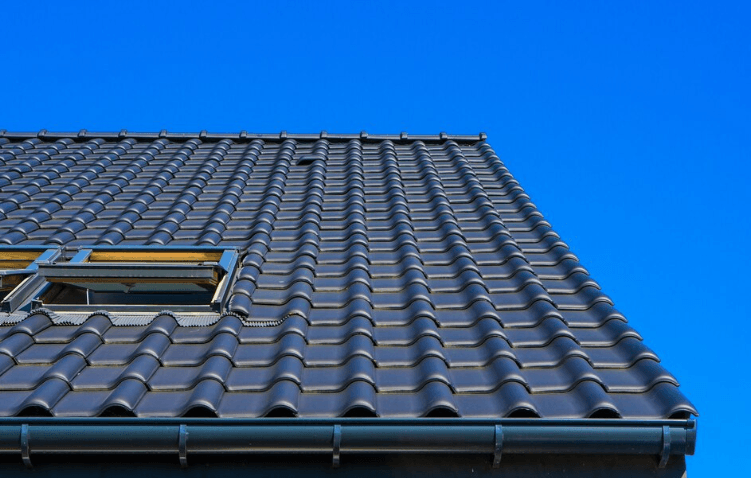 Vertical low-angle closeup of black asphalt roofing shingles on a residential building in Peachtree Corners.