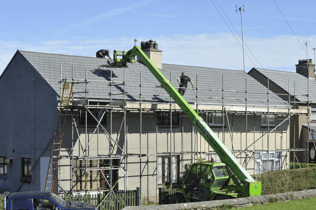 Workers fixing a commercial roof.