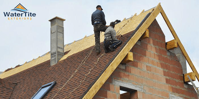 Workers fixing a commercial roof.