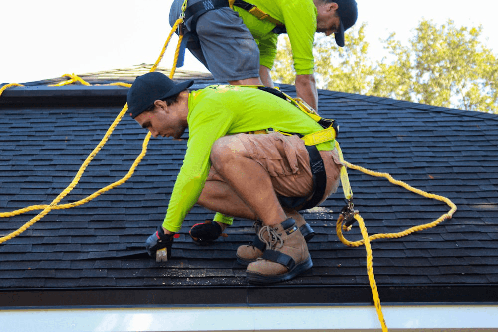 Two roofers working on a flat commercial roof during a replacement in Lawrenceville, GA.