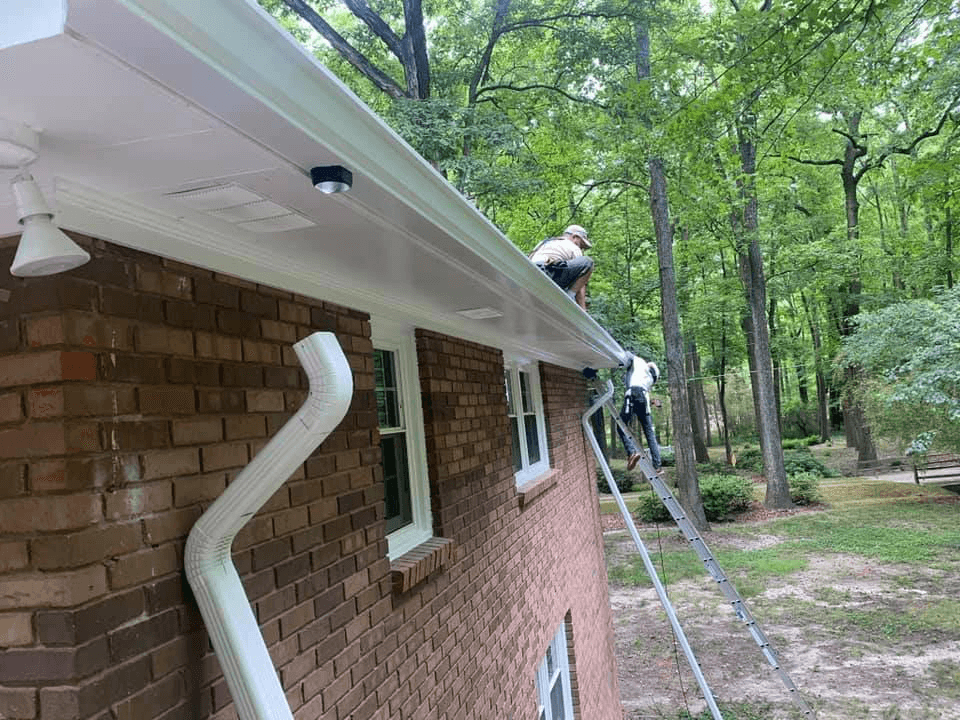 Two men inspecting roof for damage.