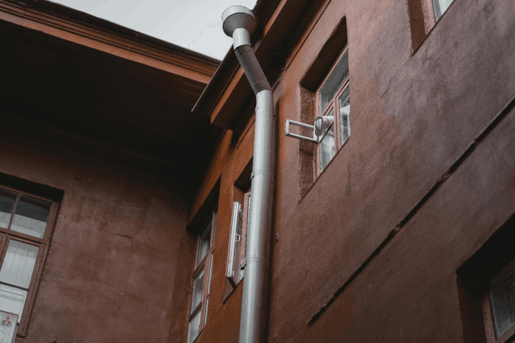 Roof drainage pipe running along the side of a building.