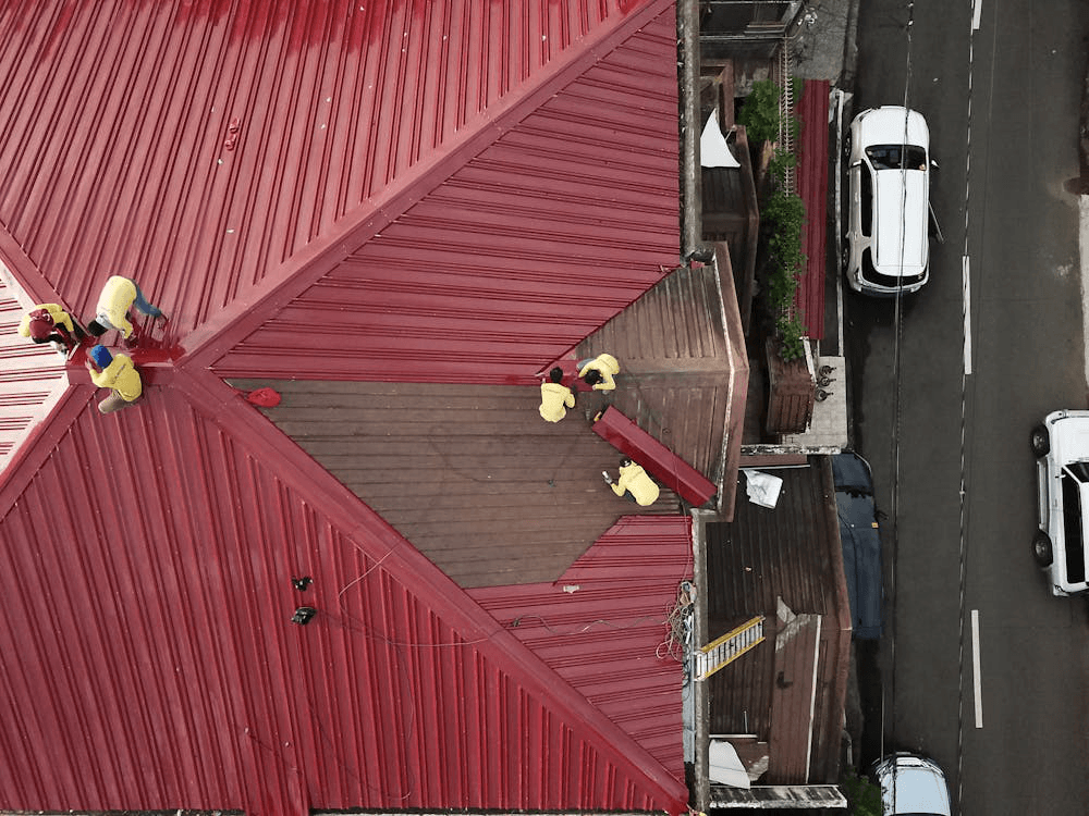 Roofing crew actively repairing storm-damaged shingles on a house roof in Johns Creek.