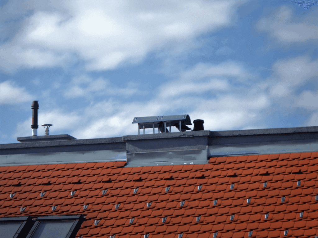 Well-maintained commercial roof with chimneys showing proactive care.