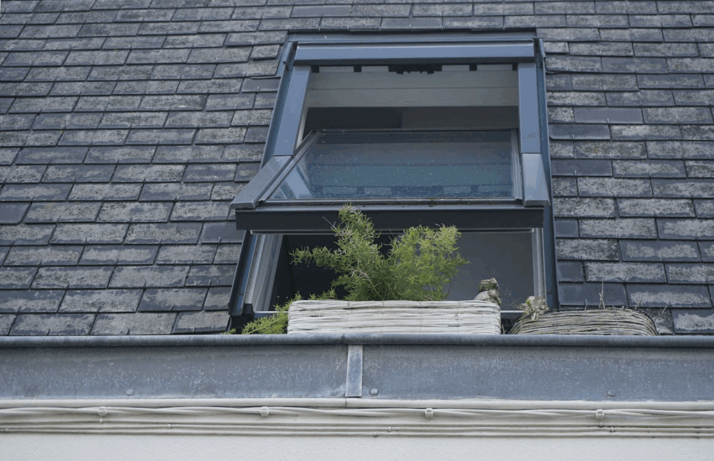 A sturdy roof with a window reflecting the reliability of professional roofers compared to risky DIY fixes.