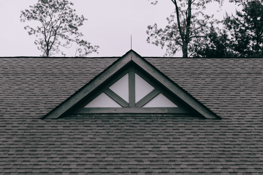an asphalt roof with a triangular-shaped window on it