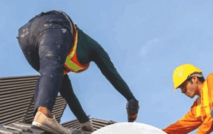 Two construction workers working on a roof.
