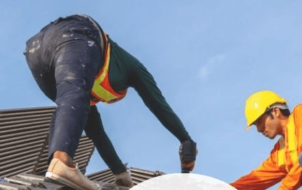 Two construction workers working on a roof.