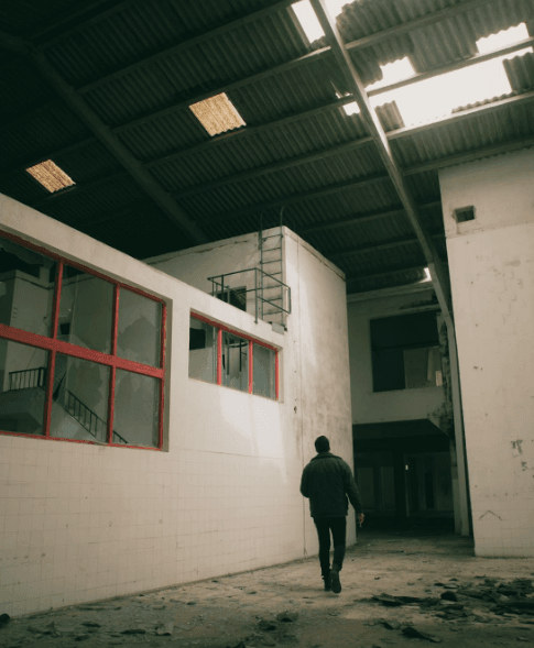 This image shows a man walking under a gutter on a property.