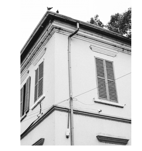 This image shows a vintage building corner with roof pipe.