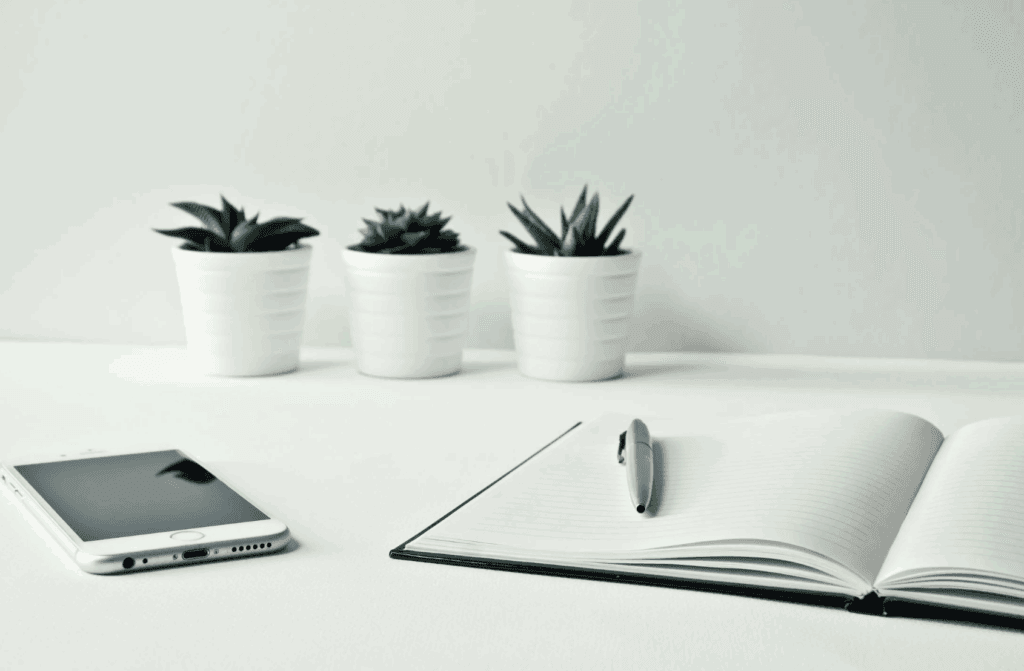 This photo shows a note, a pen and phone on a desk.