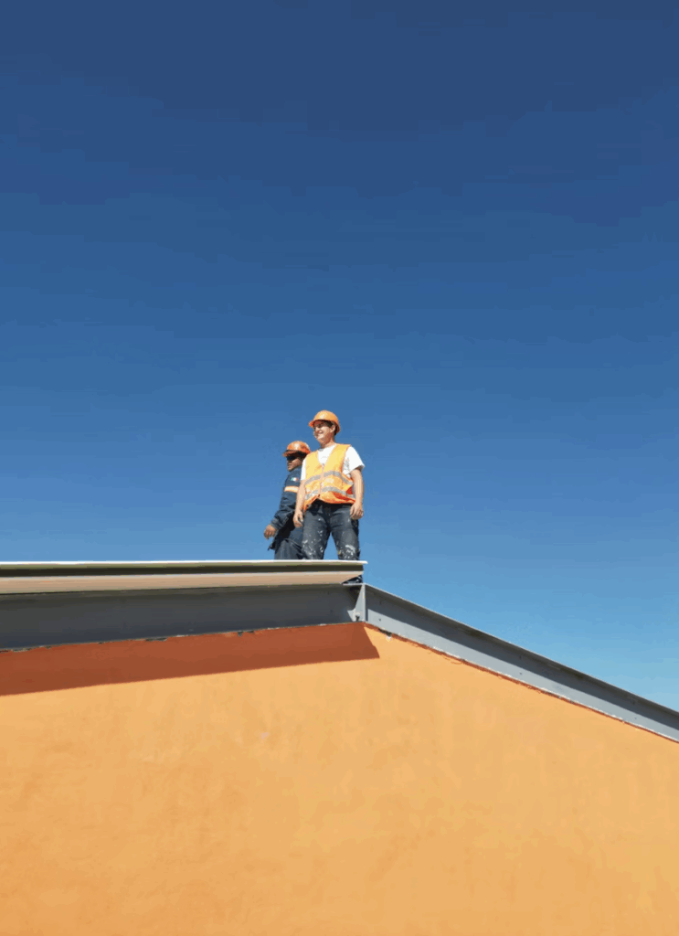 This photo shows two professionals inspecting a roof.