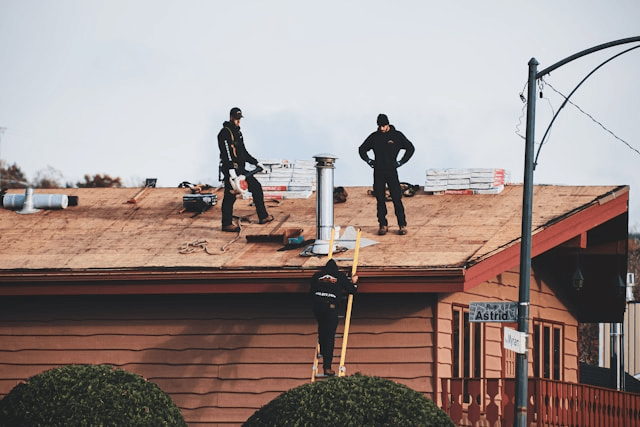This photo shows roofers inspecting and repairing a roof together