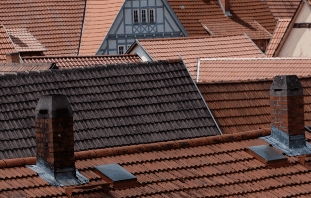This image shows the roofs of houses on a partly clouded day.