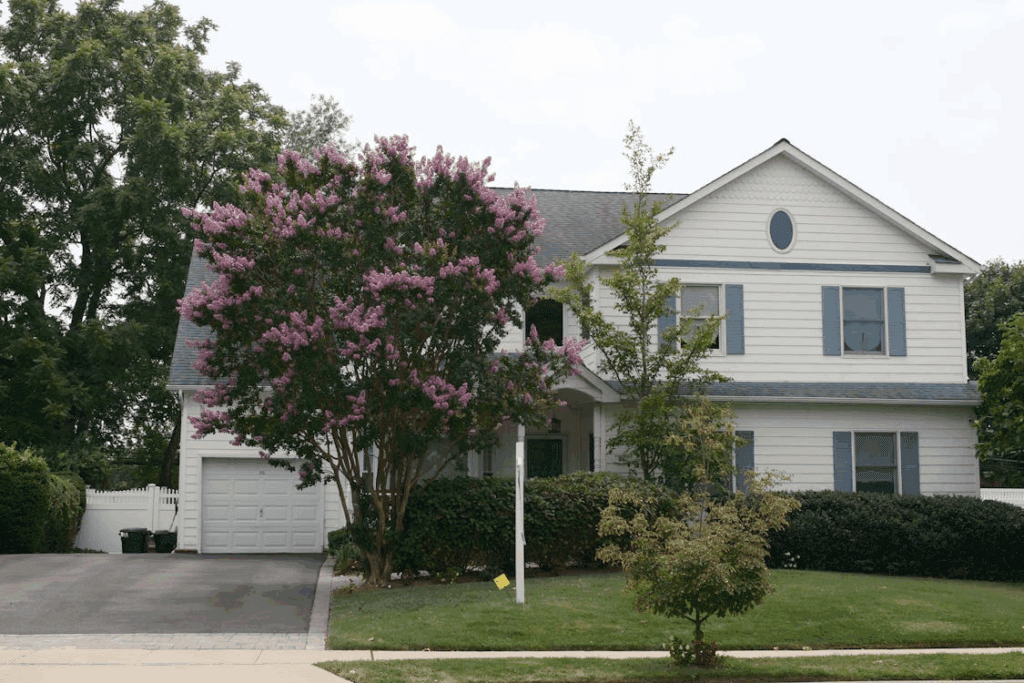 An image of an upscale house with a blooming crape myrtle.
